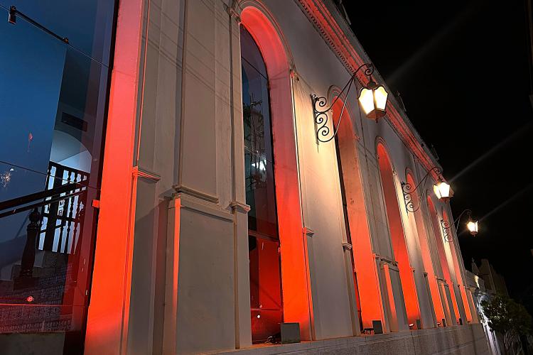 Luzes externas do Paço Municipal refletem a cor vermelha, em menção à campanha